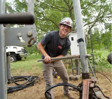 A FlowCore technician drilling a well